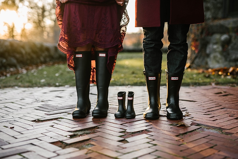 mom and dad to be wear hunter boots while posing with baby hunter boots