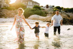 Family Photography, a mom and dad run through the ocean water with their two young sons