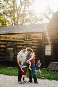 family of 5 snuggles during family photo session at Hartwell Tavern in Lincoln, MA